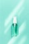 Transparent bottle with cosmetic product, soap or shampoo on mint colored background. Bright daylight