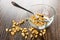 Transparent bowl with puffed wheat, spoon, scattered puffed wheat on table