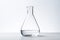 Transparent chemicals in lab flask on a white table. Scientific experimentation setup for research and analysis.