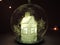 Transparent Christmas ball inside which is a beautiful white house glowing white light inside