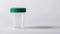 Transparent clean urine analysis container with a green lid. Clear specimen cup on a white backdrop. Concept of