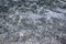 Transparent clear calm water surface with small grey pebbles sea bottom texture