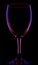 Transparent colored empty wine glass on black