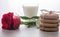 Transparent cup of milk, stack of cookies, perevyazanaya twine, lies next to a red rose. Blurred background, bokeh