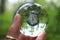 Transparent glass ball reflecting a clock in the forest