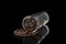 Transparent glass beaker with coffee beans on a black background