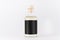 Transparent glass bottle for cosmetic, perfume, alcohol drink with  black label, cork, yellow liquid  on white background, mock up