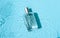 Transparent glass cosmetic perfume bottle in the blue water .