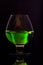 A transparent glass goblet with a green substance. A bright green substance in a glass