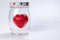 transparent glass jar with lid with three dimension 3d red hart symbol inside on white background copy text space