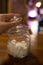 Transparent glass jar with white sugar on the table