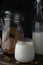 Transparent glass of milk, cookie jar, bottle of milk and almonds