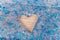 Transparent glitter slime with a heart shape hole on a wooden surface