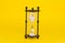 Transparent hourglass. Yellow background. In the center. Copy, text space
