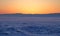 Transparent ice floe on a hummock field on the frozen Siberian Lake Baikal at sunset in winter.