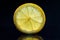 Transparent lemon slice on a dark background.