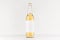 Transparent longneck beer bottle 500ml with blank white label on white wooden board, mock up.