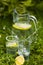 Transparent pitcher with lemonade and glass of lemonade with splashes