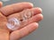 Transparent plastic bobbins from a modern sewing machine in the palm of a woman - a seamstress. Gray background. sewing machines