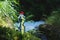 Transparent plastic A bottle of clean water with a red lid stands in the grass and moss on the background of a rugged