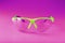 Transparent polycarbonate safety glasses on a pink background