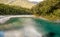 Transparent pools of deep, clear water flowing into the Makarora River offer a moment of