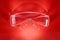 Transparent safety glasses on red