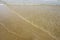 Transparent sea water in the sand by the sea. Light waves, surf. Geometrically the lines. Beach background.