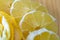 Transparent slices of lemon and peel on a cutting wooden board and blue surface. Healthy vegetarian food.