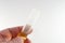 Transparent test tube in a male hand on a white background.