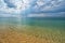 Transparent turquoise sea with dramatic cloudy sky