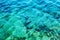 Transparent turquoise sea with sun glare. Background close-up. Space for text