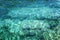 Transparent turquoise sea surface with sun glare, background. Close-up. Space for text