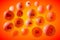 Transparent vitamin A, C, E, B1, B2, B3, B5, B6, B9, B12 pills on orange background. Vitamin and mineral complex. 3d