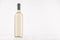 Transparent wine bottle with white wine on white wooden board, mock up.