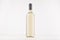 Transparent wine bottle with white wine on white wooden board, mock up.