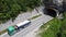 Transport truck with sand exits from tunnel on traffic road. Aerial view