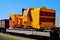 Transportation heavy mining dump truck by rail. Yellow mining truck disassembled into parts, cab, body, electric motor,