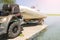 Transportation of inflatable boat on trailer. ATV quadbike moves ship to lake or river shore for launching. Beginning of