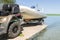 Transportation of inflatable boat on trailer. ATV quadbike moves ship to lake or river shore for launching. Beginning of water nav