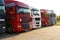 Transportation. Several trucks lined up in a row on a parking lot