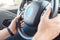 Transportation. Young man in fitness bracelet traveling by electric car sitting inside driving close-up