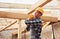 Transporting wooden boards. Construction worker in uniform and safety equipment have job on building