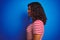 Transsexual transgender woman wearing stiped t-shirt over isolated blue background looking to side, relax profile pose with