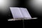 Transverse flute and blank music score rest on a black music stand isolated black background with copy space for your text