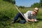 Transylvania, Romania-May 12, 2018: Old farmer resting after mowing the grass manual, traditional way of cutting the grass with