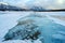 Trapped methane bubbles frozen into the water under the thick cracked and folded ice on Abraham Lake, located in the Kootenay