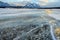 Trapped methane bubbles frozen into the water under the thick cracked and folded ice on Abraham Lake, located in the Kootenay