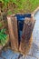 Trash can with a bent wood plank and an iron box