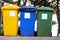 Trash can, garbage bin, recycling bin in tourist complex resort, waiting to be picked up by garbage truck. Blue, yellow and green.